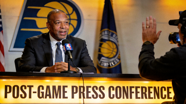 NBA球队赛后新闻发布会现场，主教练接受媒体采访